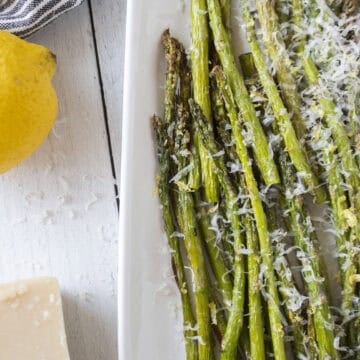 A platter of air fried asparagus topped with parmesan cheese and lemon zest.