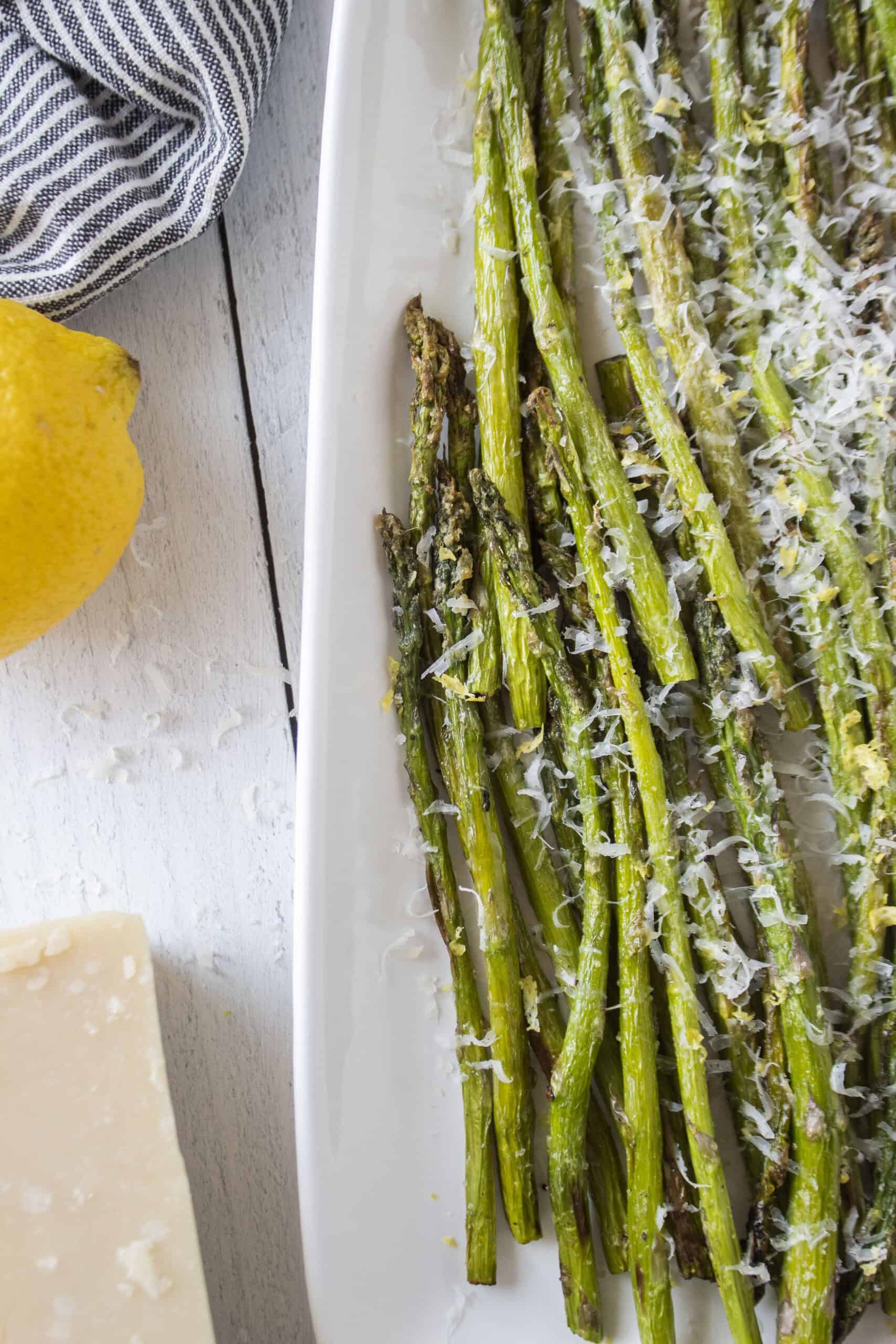 A platter of air fried asparagus topped with parmesan cheese and lemon zest.