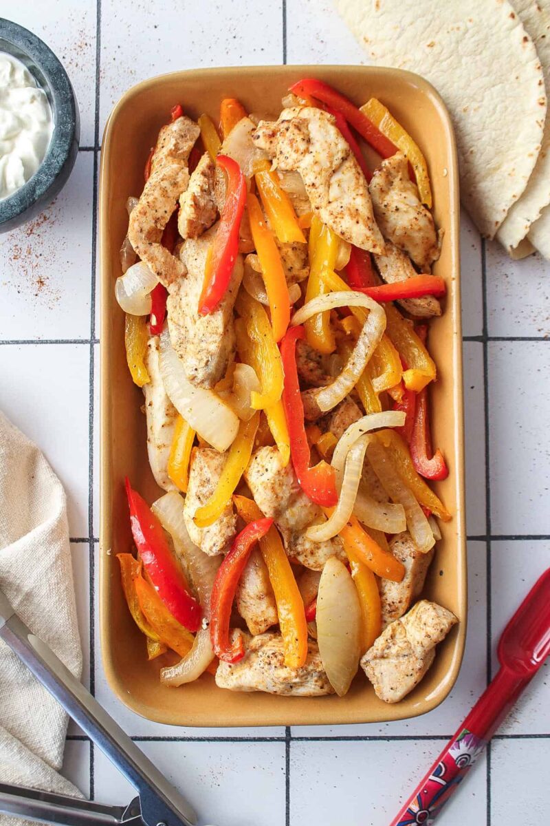 A plate of chicken fajitas cooked on a sheet pan.