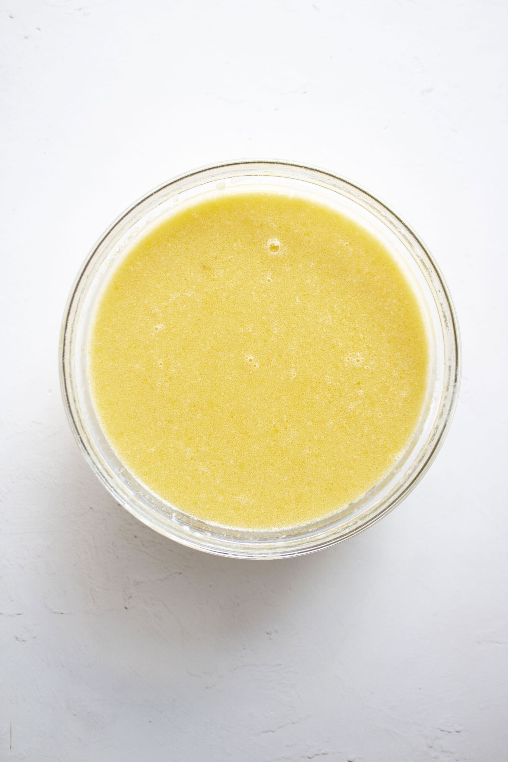 Eggs, milk, and olive oil in a mixing bowl.