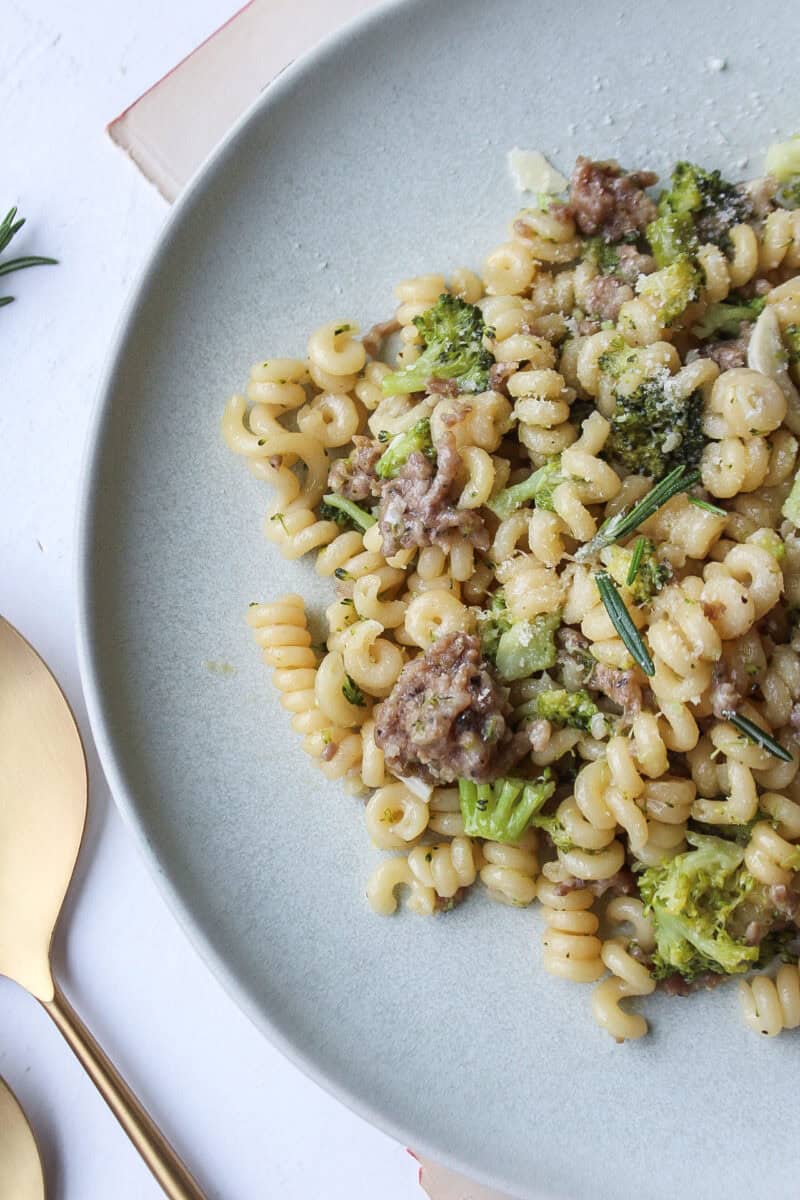 Ground sausage with broccoli and pasta on a plate.