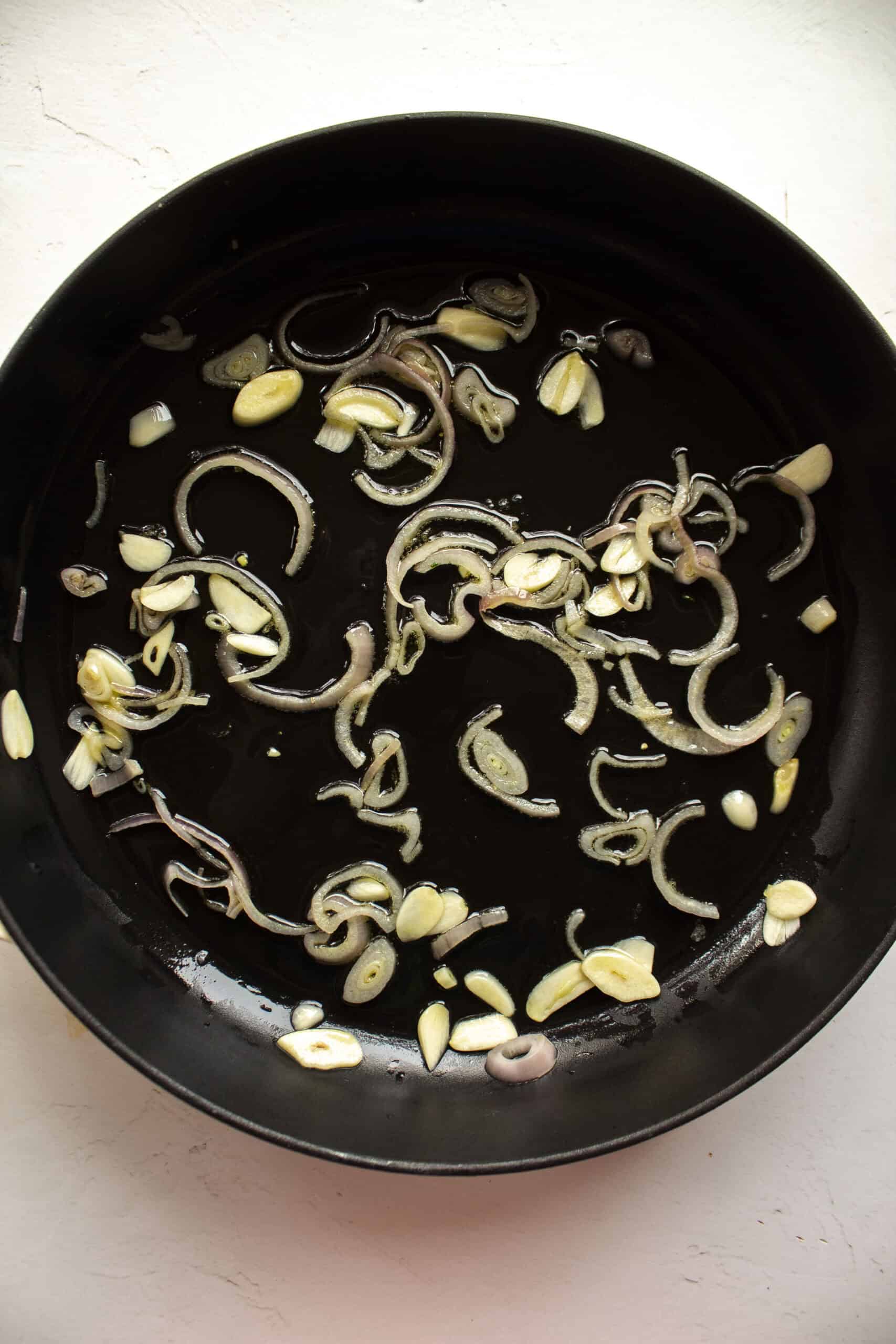Sauteed shallots and garlic in a large cast iron skillet.