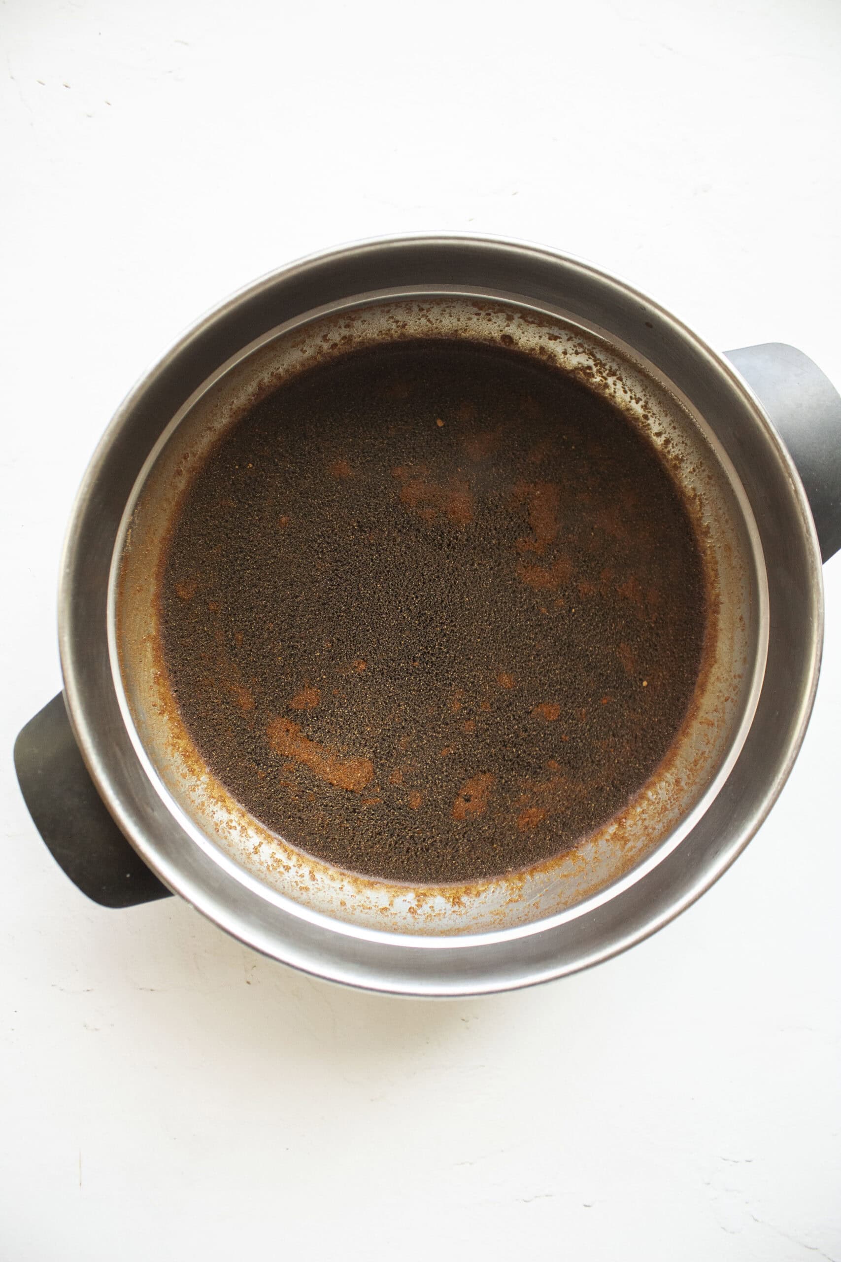 Cold espresso mixed with Kahlua and pumpkin pie spice in a bowl.