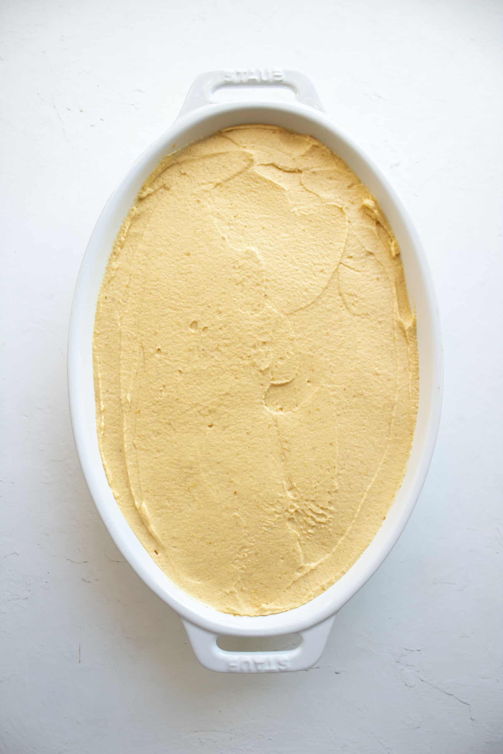 Smoothed layers of pumpkin tiramisu before being dusted with cocoa powder.