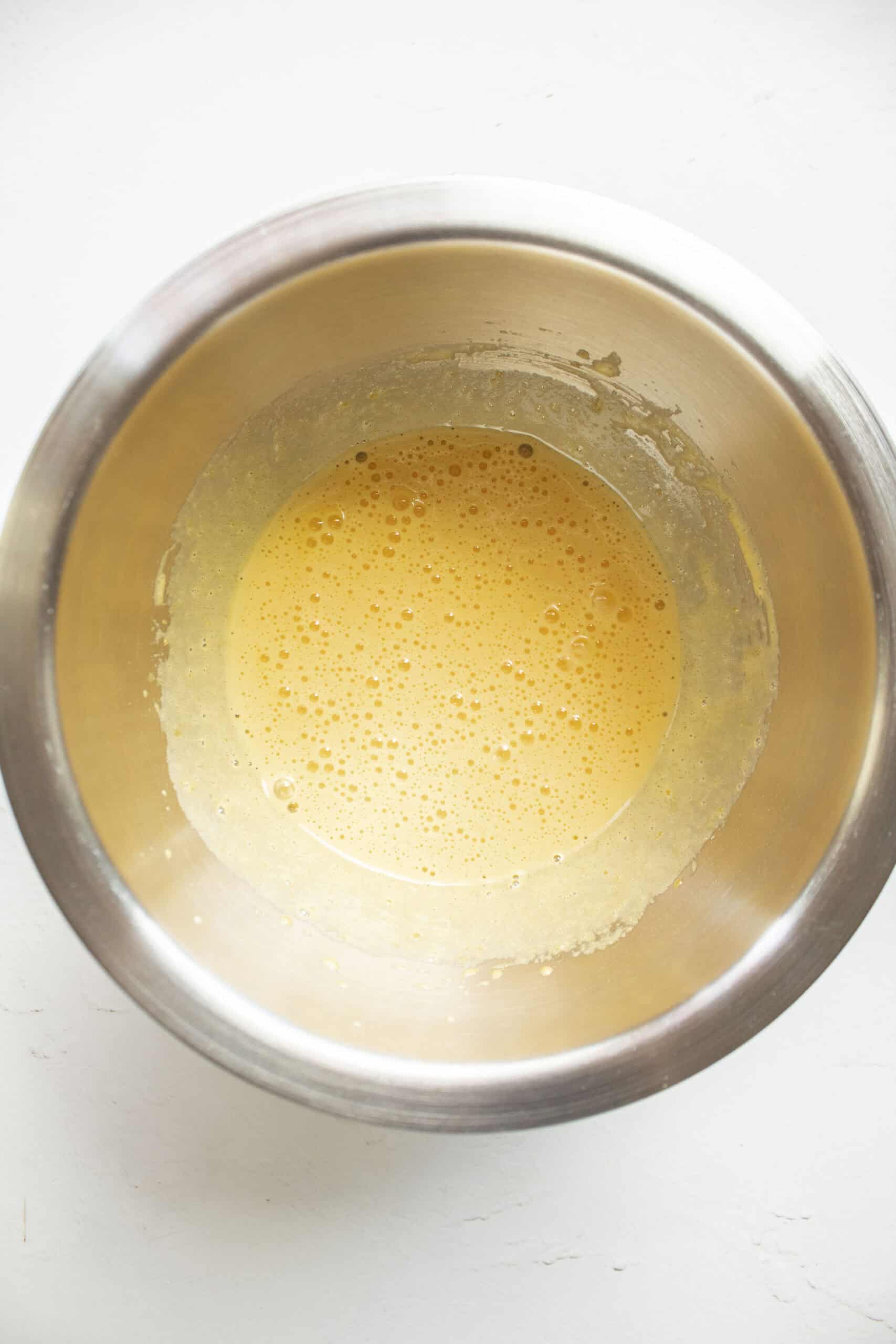 Whisked egg yolks with sugar in a small mixing bowl.