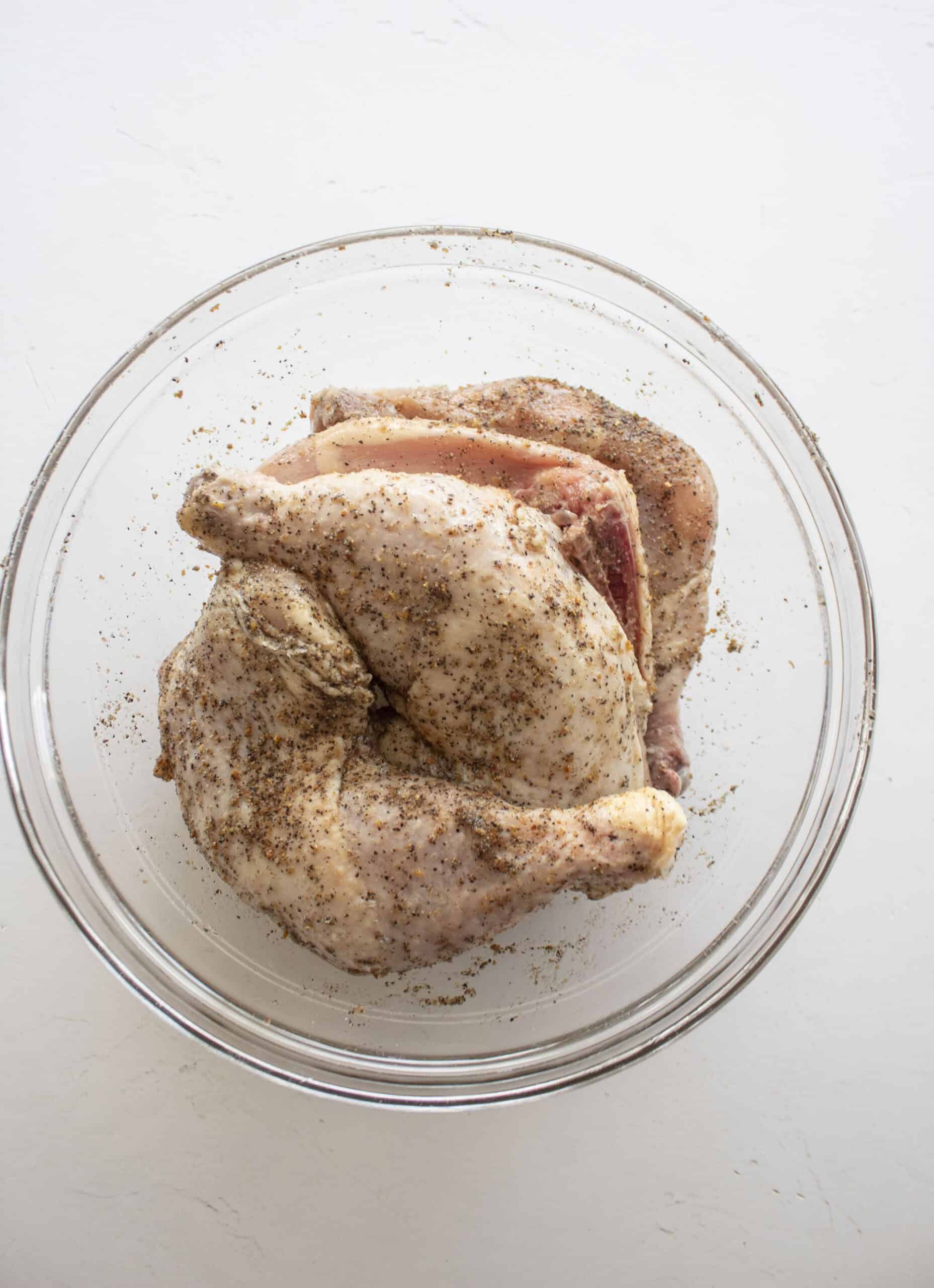 Chicken leg quarters marinated in lemon pepper seasoning and olive oil.